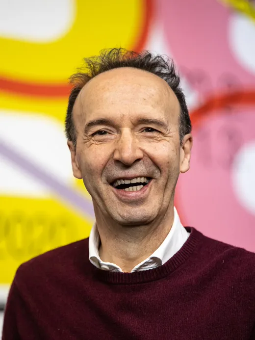 Roberto Benigni se smeje tokom javnog nastupa.